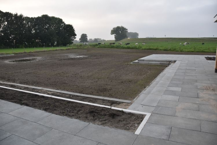 800 vierkante meter terras en bestrating met betontegels. Het gras op het ingezaaide gazon komt net op. 800 vierkante meter terras en bestrating met betontegels. Het gras op het ingezaaide gazon komt net op.