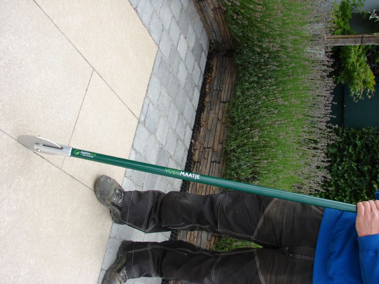 Met het voegmaatje wordt het voegmiddel tot onder in de voeg gedrukt Met het voegmaatje wordt het voegmiddel tot onder in de voeg gedrukt