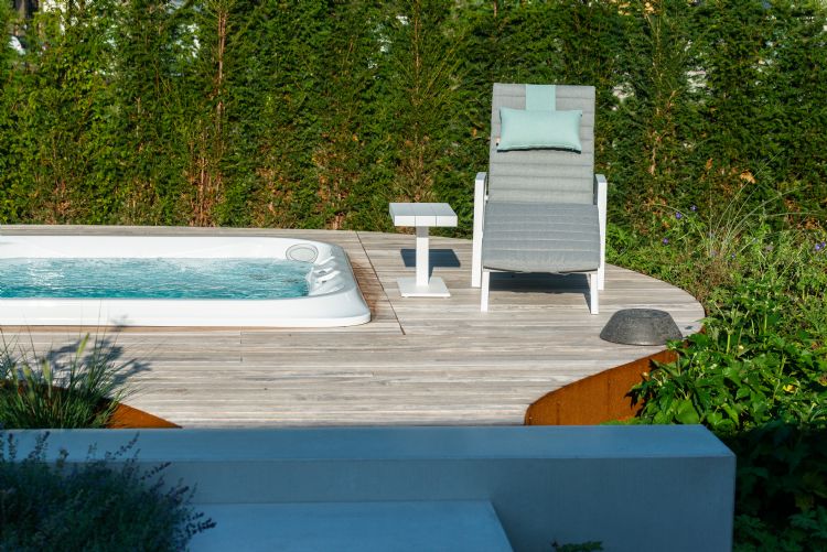 De swimspa-vlonder kreeg dezelfde vorm als de wolkgesnoeide <i>Ilex</i> in de voortuin De swimspa-vlonder kreeg dezelfde vorm als de wolkgesnoeide <i>Ilex</i> in de voortuin