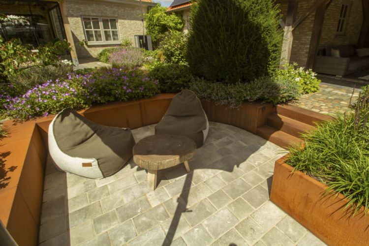 Zitkuil omringd door cortenstaal keerwanden met traptreden Zitkuil omringd door cortenstaal keerwanden met traptreden