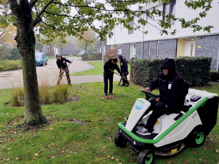 Cliënten van ASVZ Groenonderhoud in de weer met de machine Cliënten van ASVZ Groenonderhoud in de weer met de machine