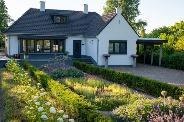 De hagenstructuur van taxus en de verdeling van de plantvakken geven de voortuin een klassiek karakter De hagenstructuur van taxus en de verdeling van de plantvakken geven de voortuin een klassiek karakter