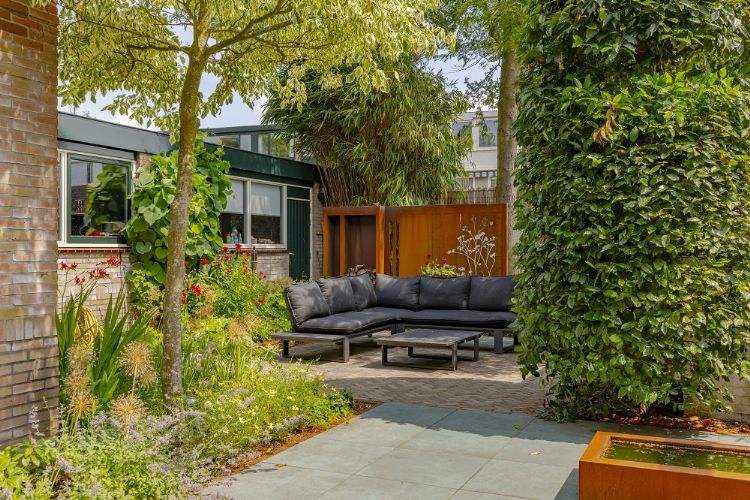 Weelderige beplanting en op de voorgrond een cortenstalen vijver van Adezz Weelderige beplanting en op de voorgrond een cortenstalen vijver van Adezz