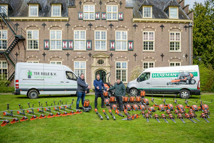 Wouter (links) en Eelco (rechts) ter Riele ontvangen het Husqvarna accugereedschap uit handen van Mark Haarman (midden).