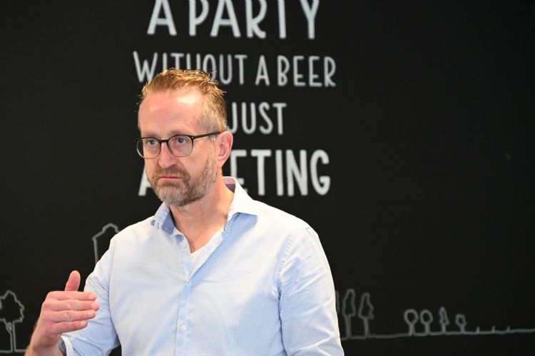 Marc Wichman Koninklijke VHG tijdens de carrousel meeting met de toepasselijke woorden op de achtergrond: 'a party without a beer is just a meeting.'