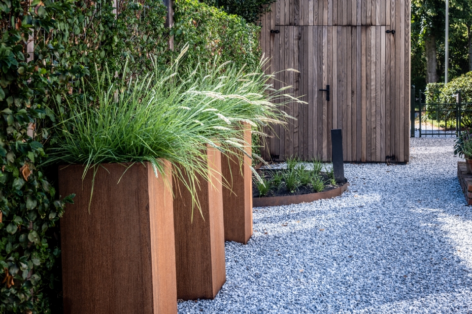Het cortenstaal van de plantenbakken geeft deze tuin een natuurlijke uitstraling.